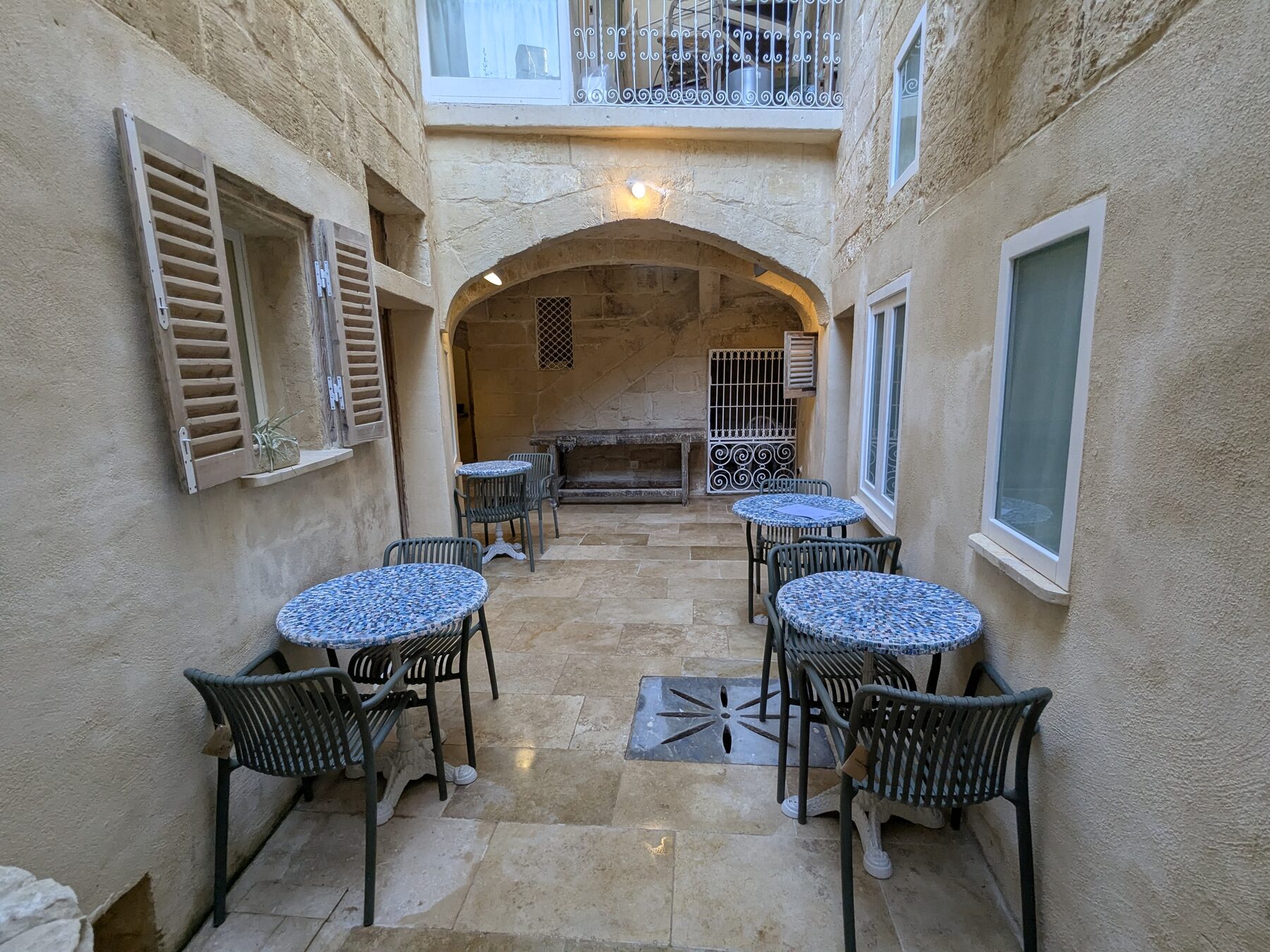 Private balcony with shutters overlooking historic rooftops