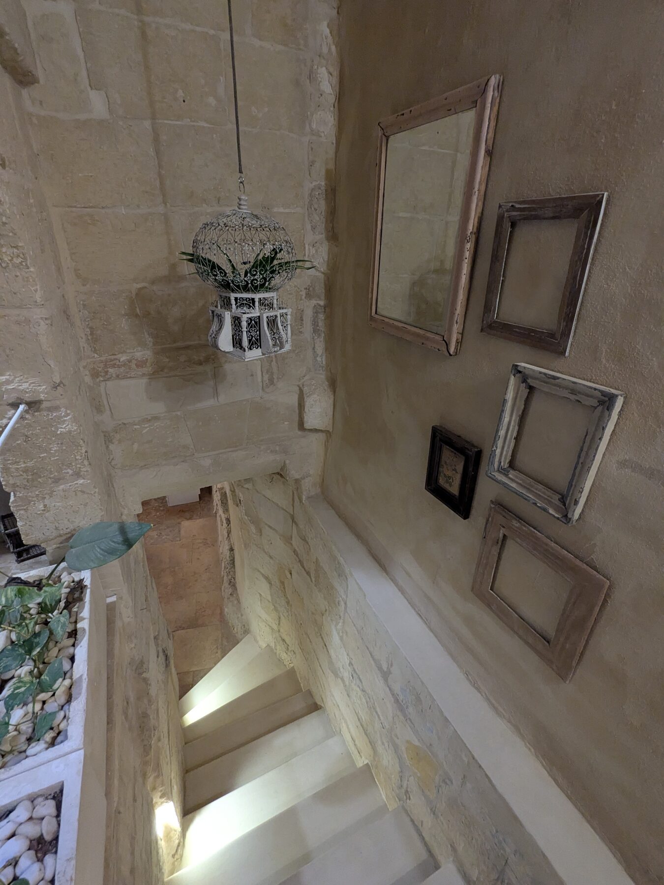 Stone staircase with vintage frames and pendant lantern